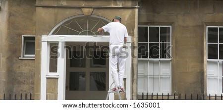A painter works on property exterior.
