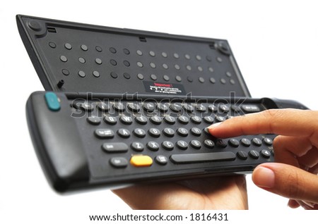 Young woman\'s hand using a remote control keyboard for Internet TV.