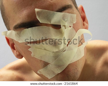 Man with mouth covered by masking tape preventing speech.