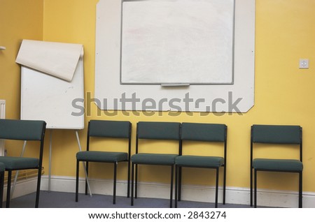 Empty classroom / meeting room with whiteboard and flipchart.