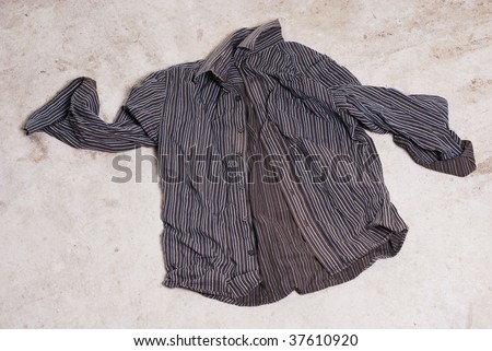 Business shirt crumpled and abandoned on an old concrete floor. Freedom or unemployment?
