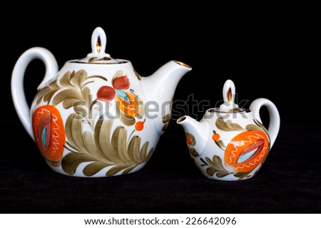 Decorative tea pots  on black velvet texture background. Tea time. Colorful lifestyle. Modern stylish design