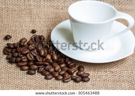 Coffee  wallpaper, background, grains of coffee plant and  white coffee set  on  burlap, sackcloth texture.