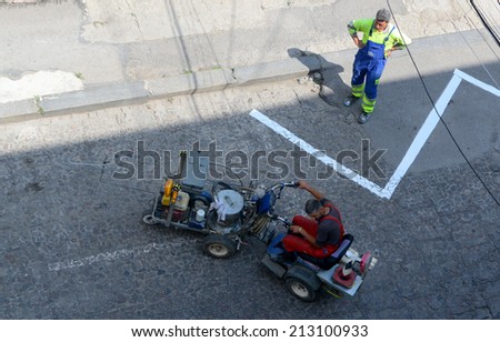 Workers put road marking machine with manual control in Sofia, Bulgaria August 26, 2014