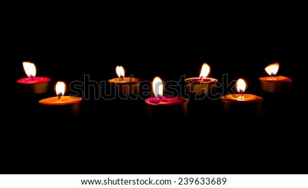 Burning candles on a dark background with warm light.