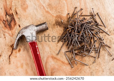 Hammer head and nails on a wooden table.