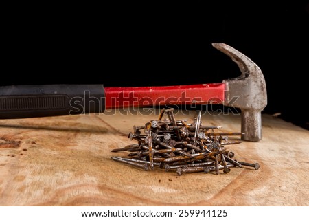 Hammer head and nails on a wooden table.