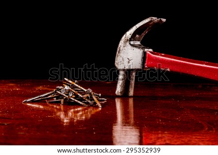 Hammer head and nails on a wooden table,Still life concept.