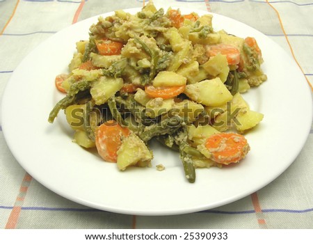 Vegetarian vegetable casserole on a white plate and checked tablecloth