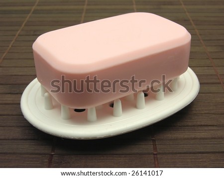 Pink soap on a soap dish on a brown background