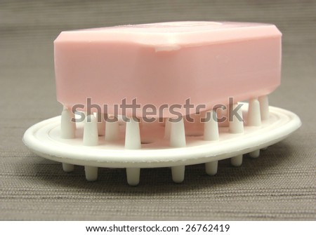 Pink soap on a soap dish on a gray background
