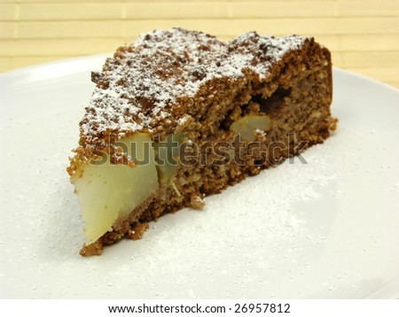 One slice of pear cake on a white plate dusted with powder sugar