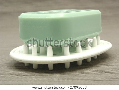 Green soap on a soap dish on a gray  background