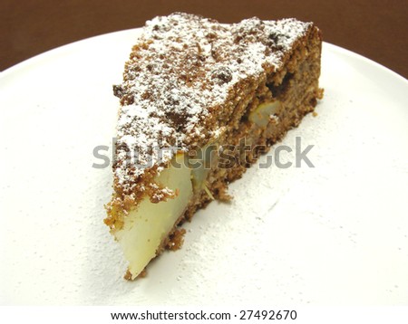 One slice of pear cake on a white plate dusted with powder sugar