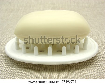 Beige soap on a soap dish on a beige background