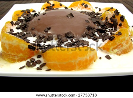 Chocolate pudding with yoghurt, sliced tangerines and chocolate granules