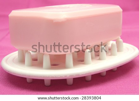 Pink soap on a soap dish on a pink background