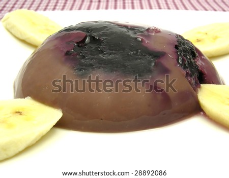 Chocolate pudding with blueberries, banana and pieces of almonds
