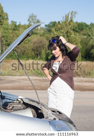 Attractive young woman having problems with her car