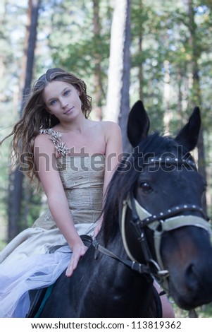 Young woman horseback riding in forest