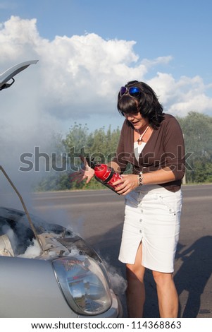 Woman with fire extinguisher near smoking car