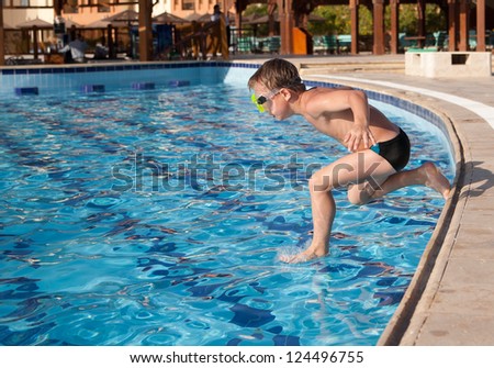 Boy in glasses jumping into the pool