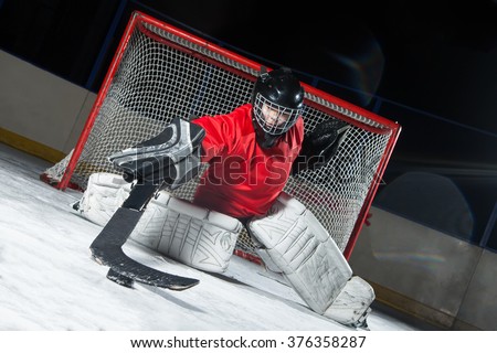 Hockey goalie blocking a puck with stick