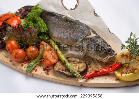 Grilled sea bass fish with vegetables isolated on white background