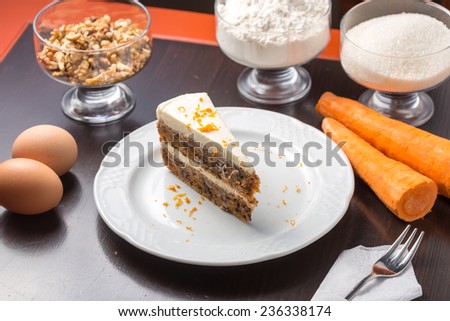 Slice of carrot cake with ingredients on the table