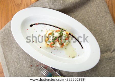 Cooked fish fillet with tomatoes and white sauce on the table
