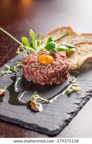 Steak Tartare with bread toasts served on a stone plate