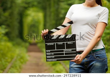 Woman holding clapper board in her hands. tunnel of love in ukraine