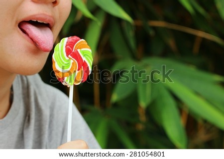 Young woman eating candy at the park.