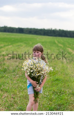girl with a bouquet of daisies in a field on the nature