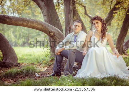bride and groom in nature, near a large tree