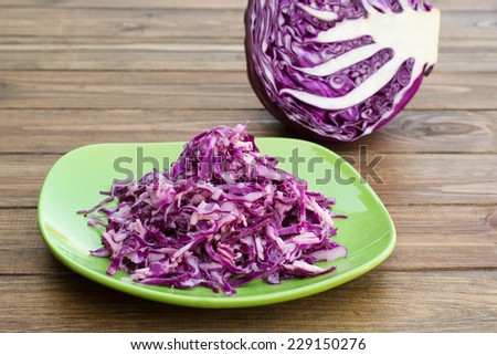 cabbage salad in a plate on the table and half of cabbage