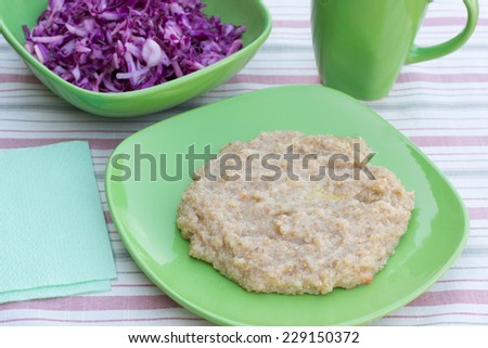 wheat porridge and cabbage salad in a plate on a wooden table