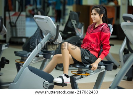 Women exercise bike in the gym.
