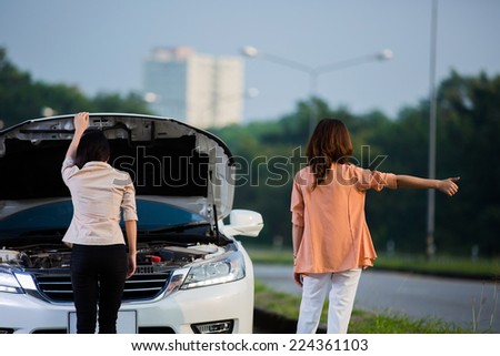 Two Asian women are doing a breakdown on the road stance to the car park