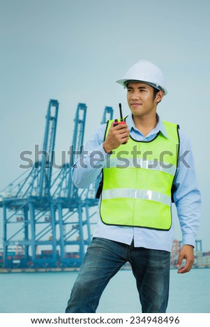 Asian Male engineers Radio talk at the port shipment