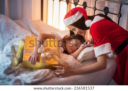 Santa claus lady giving gifts to children. We were sleeping on the bed. On Christmas Day