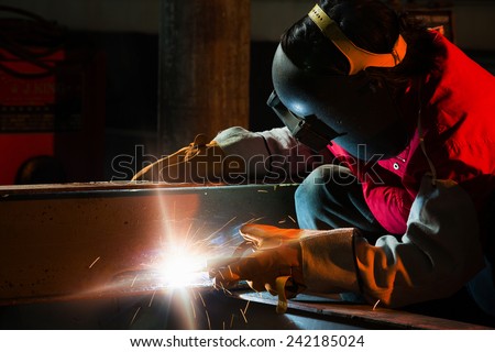 Welder welding steel sitting in the industry