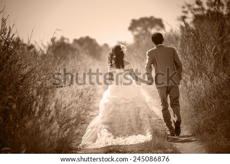 Married couples in love on Valentine\'s Day. Holding hands walking on the street. The fields,Sepia color