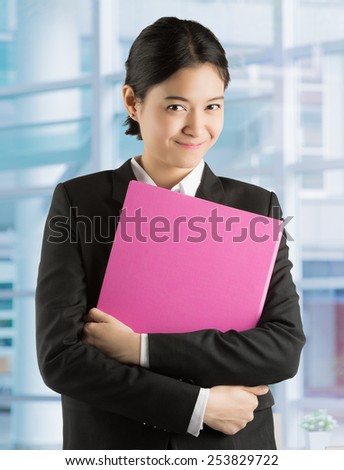 Asian businesswoman Are holding a file Expression eyes with hope and confidence in the office