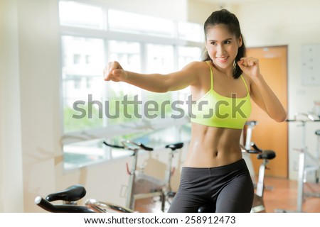 Woman exercising in the gym Cycling for Weight Loss For good health ,She acted with punch