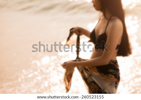 Asian women tie at the waist for a relaxing walk on the beach, blur, soft focus