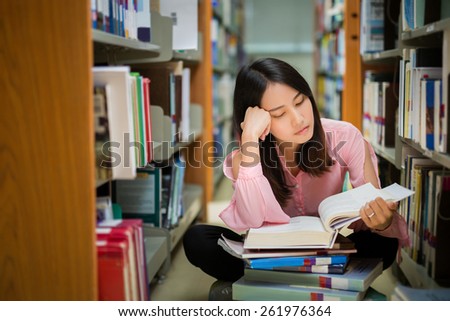 Asian student was reading in the library and Understanding Read books