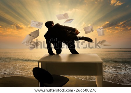 Businessman jumping over the desk Out to sea in front of him. The paper on the table, he drifted blown up. Freedom to the world of work.