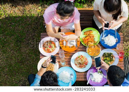 Asians eat on vacation, everyone picks up the phone to use while eating