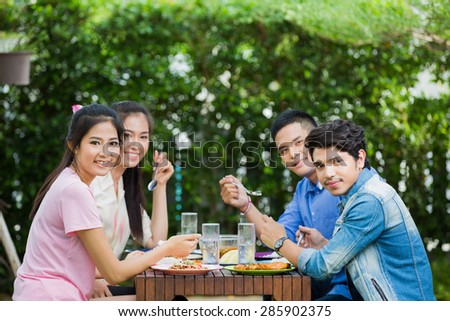 Asian ethnicity Having breakfast in the garden at home. Everyone laughed and enjoyed